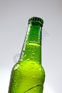 灰色背景中的湿绿色啤酒瓶图片