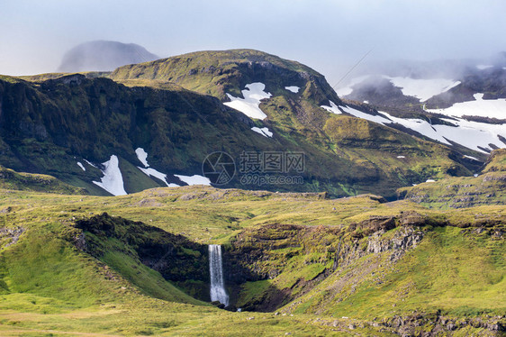 冰岛的草原瀑布和遥远的冰山图片