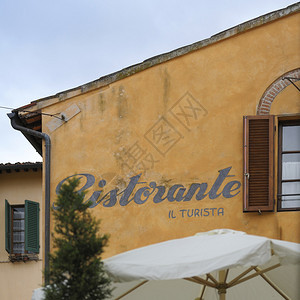 美丽的意大利餐厅标志Ristorante在典型的Tusacany黄色的建筑物上为您的宣传册网站和传单提供有关意大利文化食物和其他图片