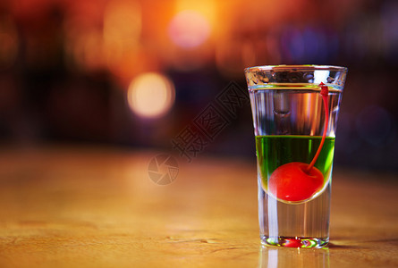 杯中的白绿色鸡尾酒与樱桃背景图片