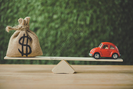 玩具汽车和钱袋用美元符号平衡绿色图片