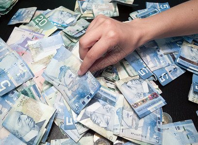 个人用手从纸质货币堆积中挑背景图片
