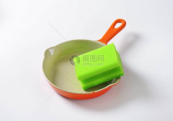 陶瓷锅上的绿色厨房海绵图片