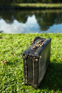 河边的旧黑色手提箱浅自由度图片
