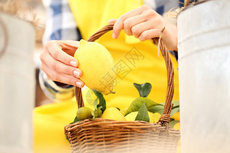 手采一个柠檬放在柳条篮子里图片