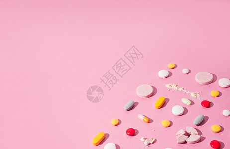 粉红色桌子上不同药丸的图像图片