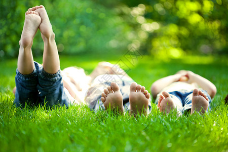 一群快乐的孩子躺在春天公园的绿图片
