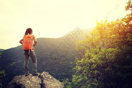 在森林山顶徒步旅行的年轻女图片