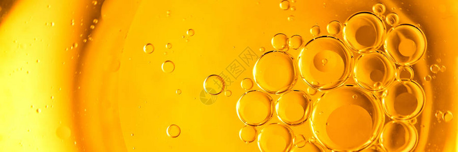 黄色和橙色的泡沫水中的油滴橄榄油背景图片