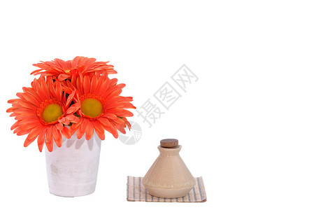 白色背景竹垫上带小瓶的彩色花盆图片