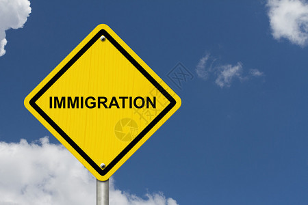 移民警告标志黄色警告路标与词移图片
