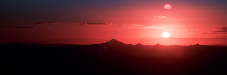 太阳和山脉的剪影从坦伯林山看图片