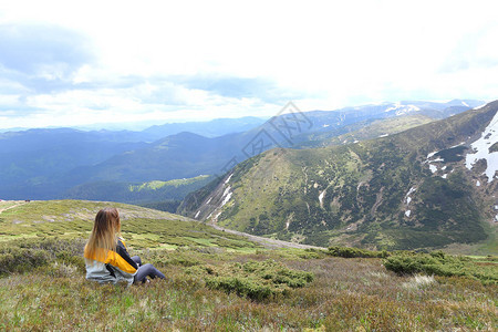 金发女游客坐在阿尔卑斯山上观光山区的旅游和暑假概念图片