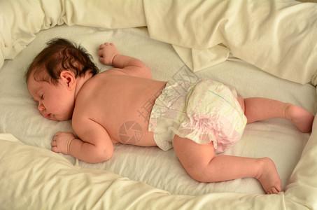 一个新生婴儿的脸在婴儿床上安静地裸睡复制空间新生儿婴儿母亲母育儿和生活方背景图片