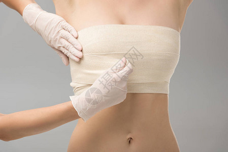 乳胶手套中整形外科医生和胸绷带患者的部分视力图片