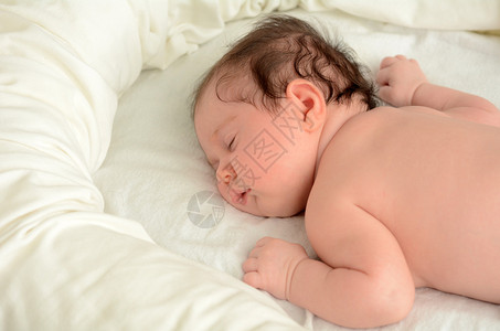 一个新生婴儿的脸在婴儿床上安静地裸睡复制空间新生儿婴儿母亲母育儿和生活方背景图片