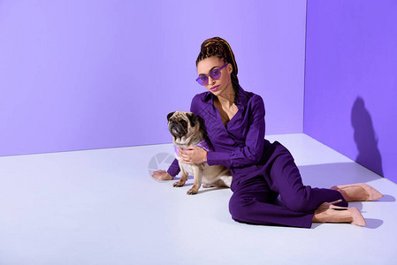 穿着紫色时装和狗一起穿紫色西装的时髦女孩图片