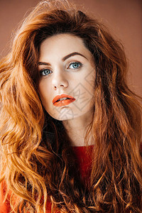 棕色背景上孤立的长红头发的女人图片