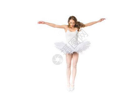 年轻芭蕾舞女有张开的双臂跳跃和向下看图片