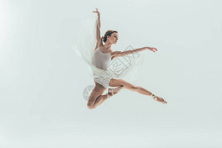 穿着白裙子的年轻优雅芭蕾舞女郎在演播室跳跃图片