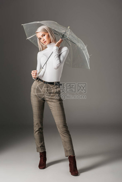 身穿白色高领毛衣和灰色裤子戴着透明雨伞灰图片