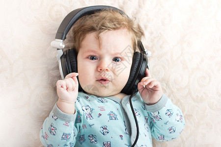 在大耳机里装着有趣的婴儿一个小男孩的肖像图片