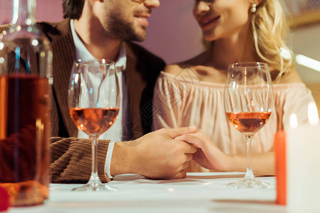 夫妻手握和在餐桌上与餐馆酒杯约背景图片