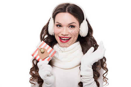 穿着围巾手套和耳服的年轻快乐妇女带着小包裹的礼物图片