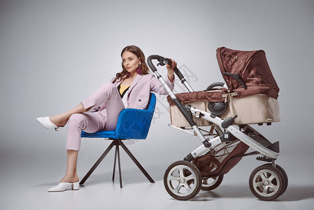 时髦的妇女坐在椅子上坐着婴儿图片