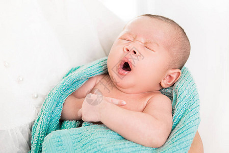 可爱的新生婴儿在妈怀里睡觉时打哈欠图片
