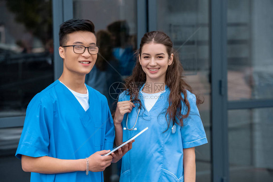 持有平板和看医科大学照相机的多文化医学生图片