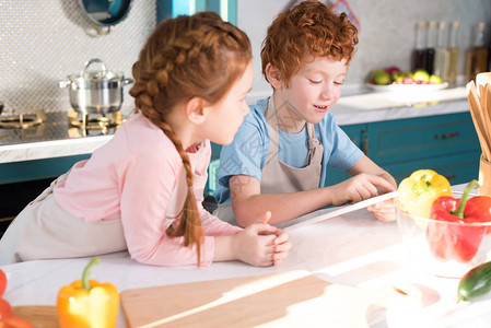 可爱的小孩在厨房一起做饭时用数字板同图片