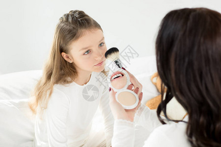 母亲在化妆时带着化妆镜和刷子背景图片