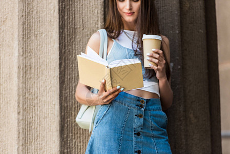 美少女在街上阅读书籍和咖图片