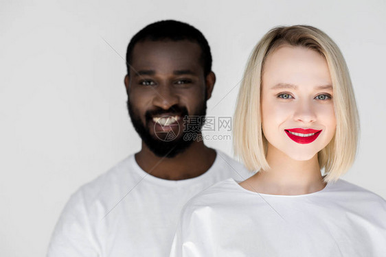 微笑着的多元文化情侣看着在白色上图片