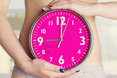 生物时钟女人在胃前抓钟粉色时钟在女图片