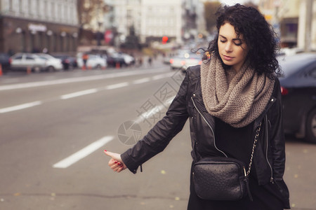 欧洲城市街道上戴着围巾的黑发美女图片