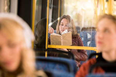 城市公共汽车上年轻女阅读书图片