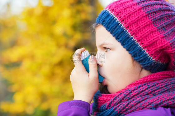 女孩在秋日使用吸入器治疗哮喘发作呼吸系统疾病的吸入治疗浅景深儿童图片