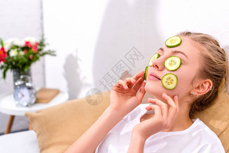 年轻女子在家里用黄瓜片敷脸图片