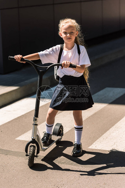 在街上骑着摩托车的背车的小女学图片