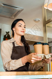深褐色女服务员在咖啡厅纸杯中喝咖啡图片
