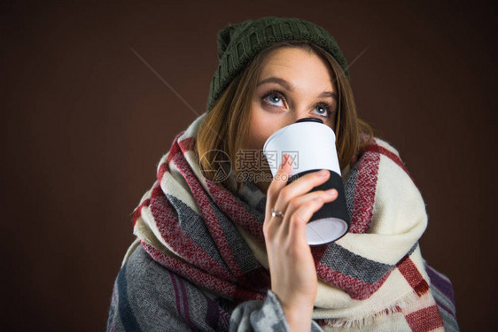 身着冬衣喝热温杯水的女人图片