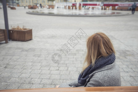 雨天背影身着灰色大衣和围巾的美丽的金碧发年轻caucasians女人在寒冷的雨天阴云背景