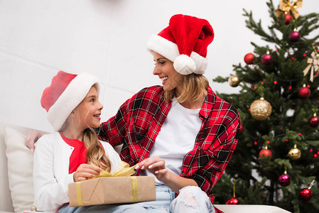 戴着圣诞礼帽的母亲和女儿带着圣诞节礼物图片
