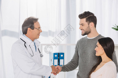 医生和微笑的病人握手图片