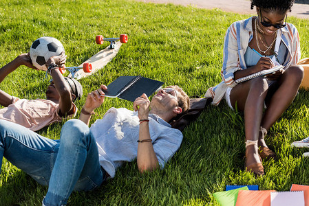 在公园学习时躺在绿草上学习的背景图片