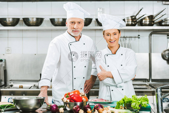 在餐厅厨房做饭时穿着制服的男女厨师双臂图片