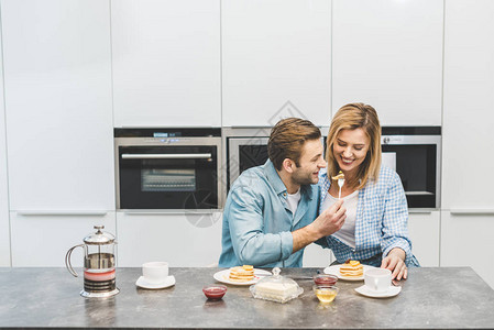 一对夫妇一起在家厨房吃早背景图片