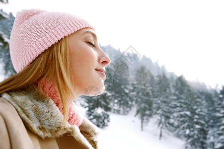 一位年轻迷人的女子在雪山呼吸新鲜空气图片